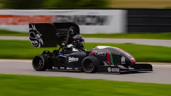 Zdjęcie bolidu wyścigowego z czarnym kolorze na torze