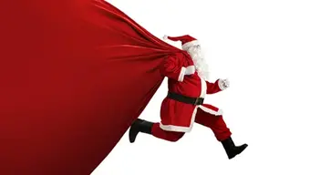 Grafika przedstawiająca postać św. Mikołaja, który biegnie trzymając na plecach duży worek z prezentami.